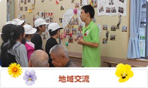 職員が入居者向けに地域交流イベントの説明をしている様子
